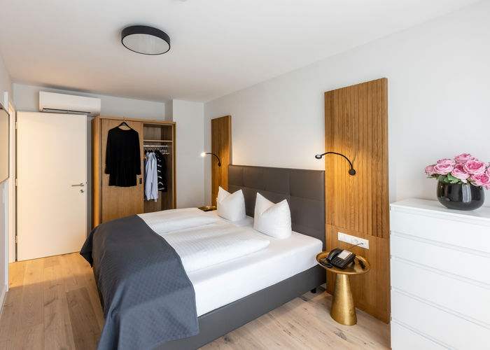 Das modern ausgestattete Schlafzimmer mit Kleiderschrank und Doppelbett im Apartment Deluxe XL.
