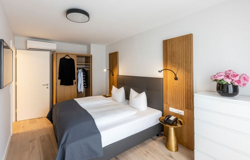 The modern bedroom with wardrobe and double bed in the Deluxe XL apartment.