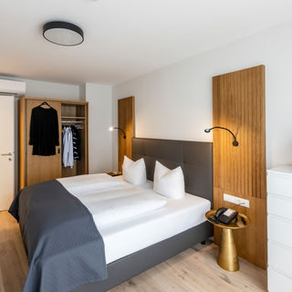 Das modern ausgestattete Schlafzimmer mit Kleiderschrank und Doppelbett im Apartment Deluxe XL.