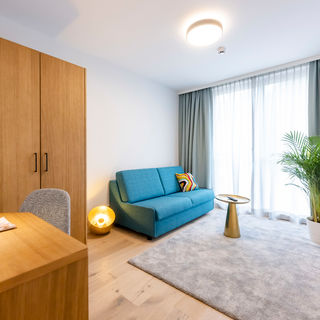 The modernly furnished additional room with couch, carpet, wardrobe, desk and much more in the Delux XL apartment.